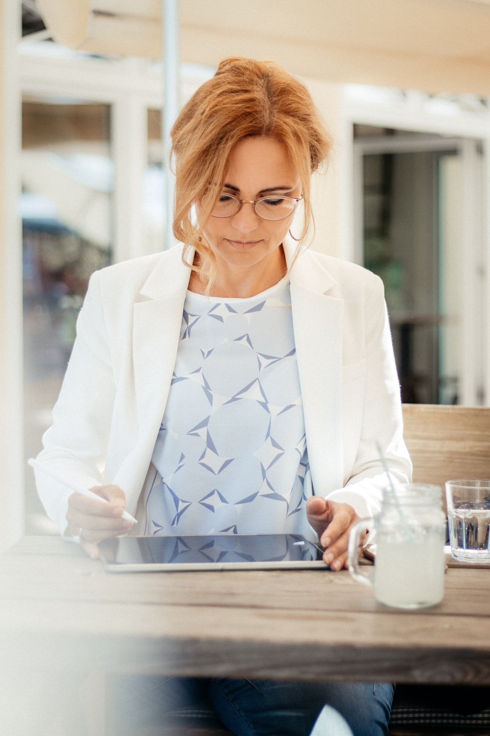 Heike Bruckhuisen arbeitet am Tablet an einem Cafétisch